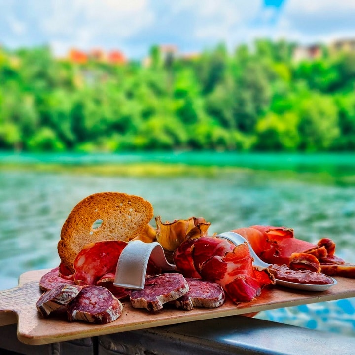 Tagliere di salumi e pane con vista sul fiume Adda al Ristorante Al Molo