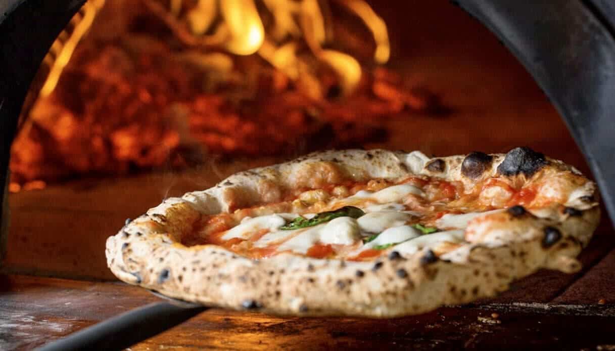 Pizza margherita appena sfornata davanti al forno a legna del ristorante Al Molo